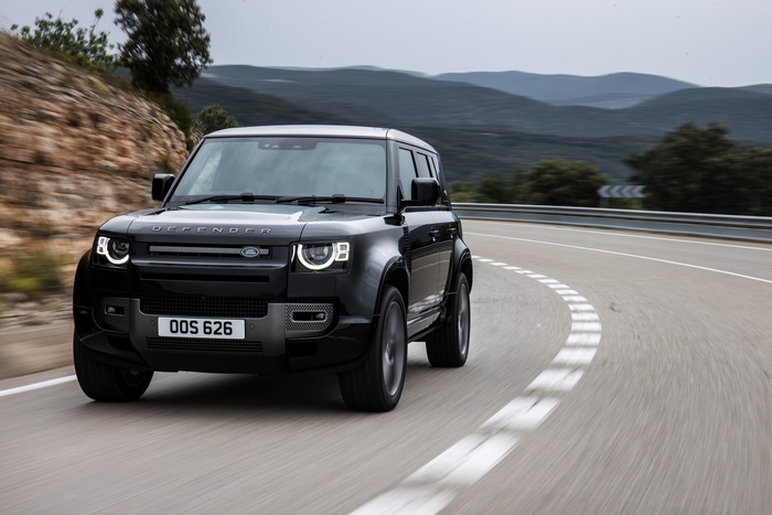 Black Land Rover Defender 110 V8 on a winding road