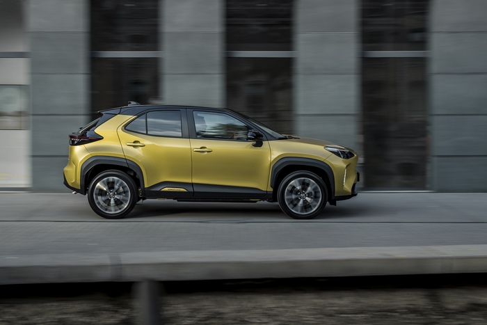 Elegant yellow Toyota Yaris Cross Hybrid SUV in motion
