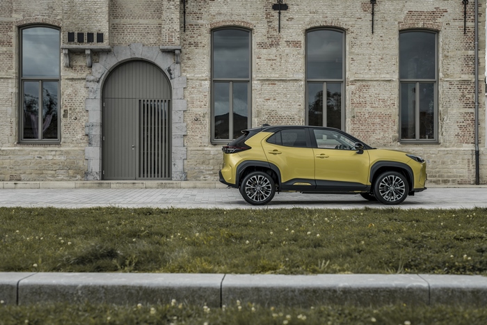 Elegant Yellow Toyota Yaris Cross Hybrid SUV by building