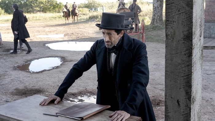 Adrien Brody in Chapelwaite, leaning on table
