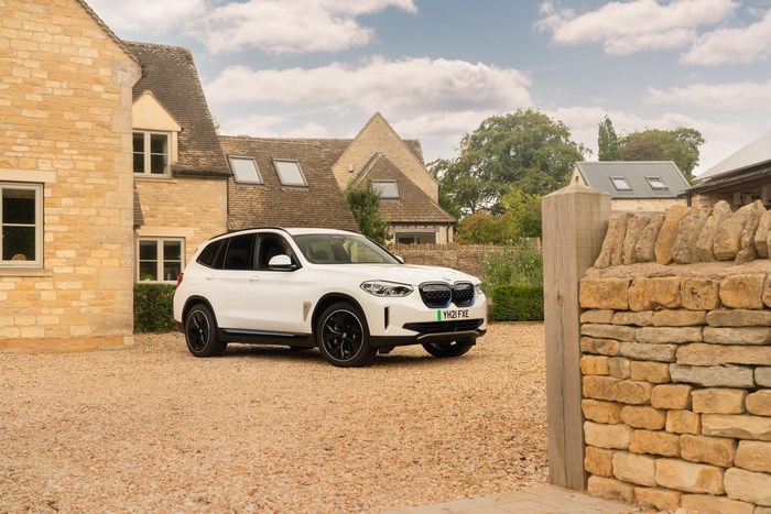 White BMW iX3 Premier Edition SUV at stone house
