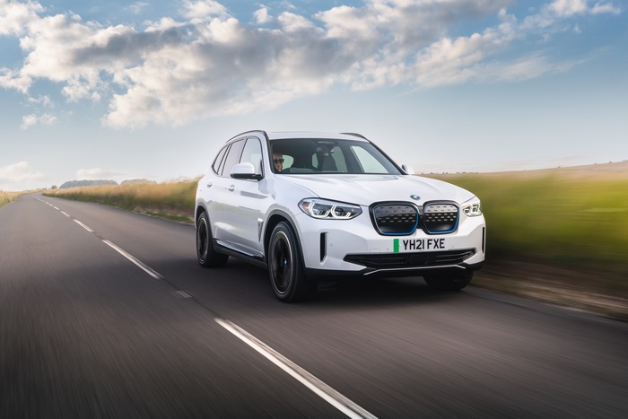White BMW iX3 electric SUV driving on a road