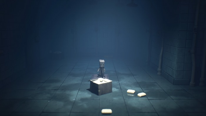 Little Nightmares II: Mono in a dark, tiled room