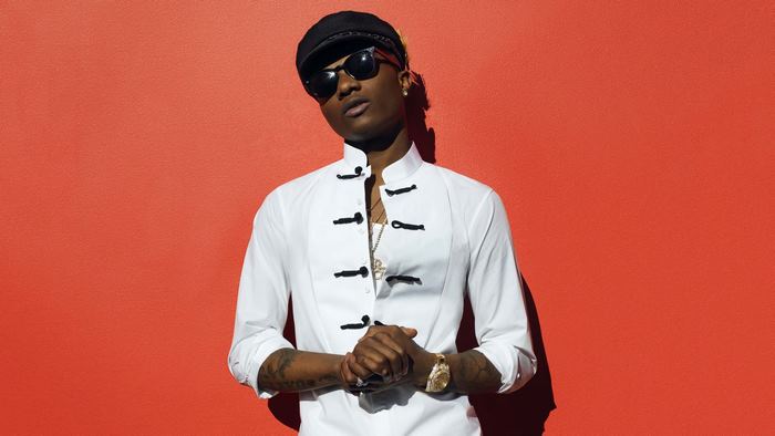 WizKid in white shirt and sunglasses on red