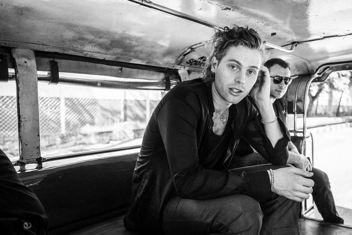 Luke Hemmings in a black and white vehicle