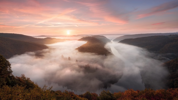 Golden sunset over a foggy river bend