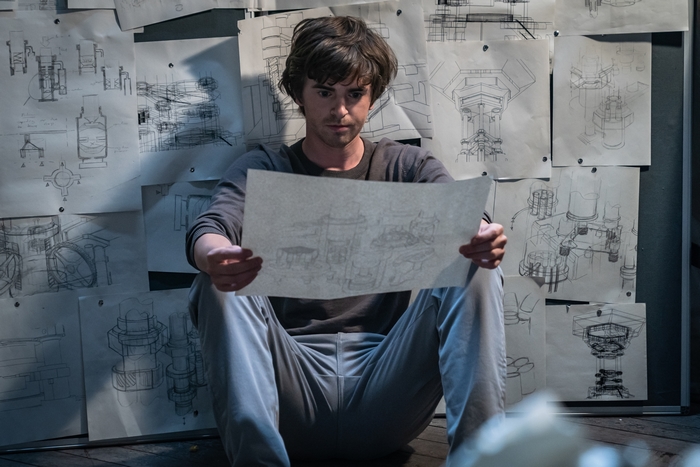 Freddie Highmore studying blueprints in The Vault