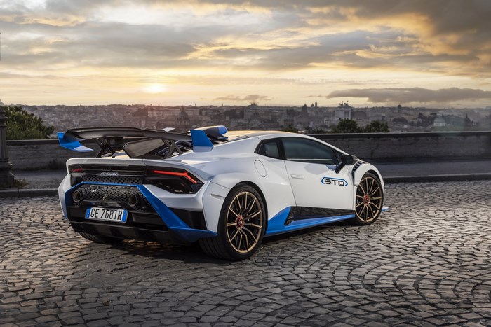 White Lamborghini Huracán STO supercar overlooking city at sunset