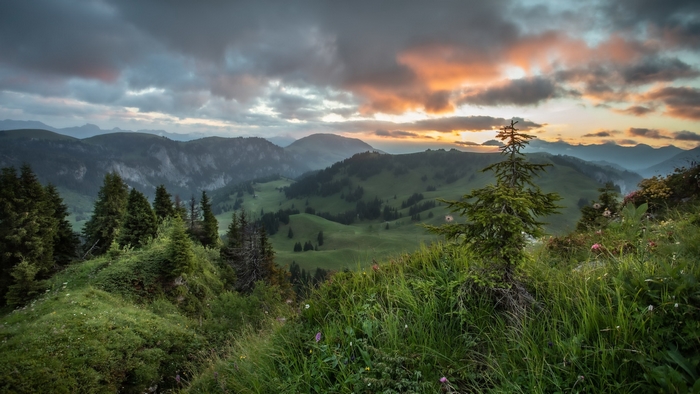 Lush mountain landscape with a vibrant sunset sky