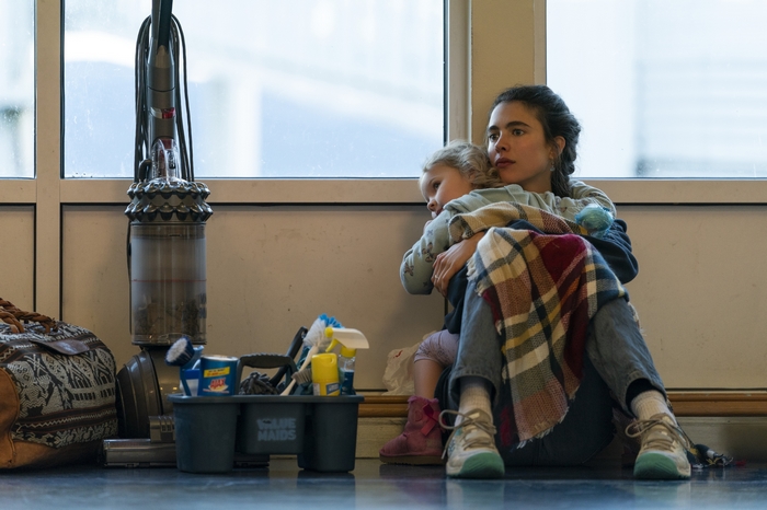 Margaret Qualley as a maid resting with her child