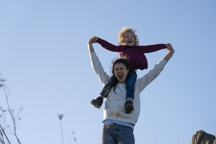 Margaret Qualley and child joyful on shoulders