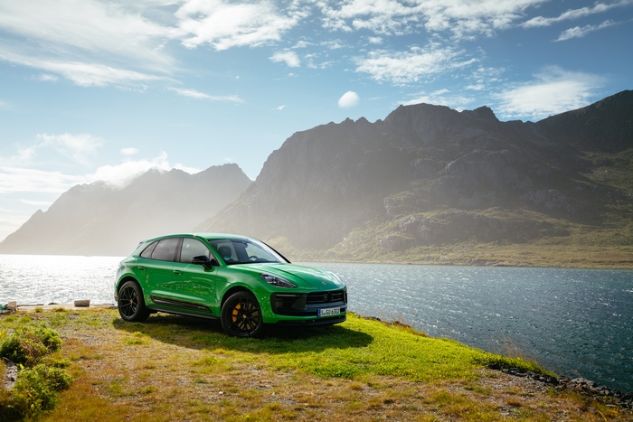 Green Porsche Macan GTS SUV in a scenic mountain landscape