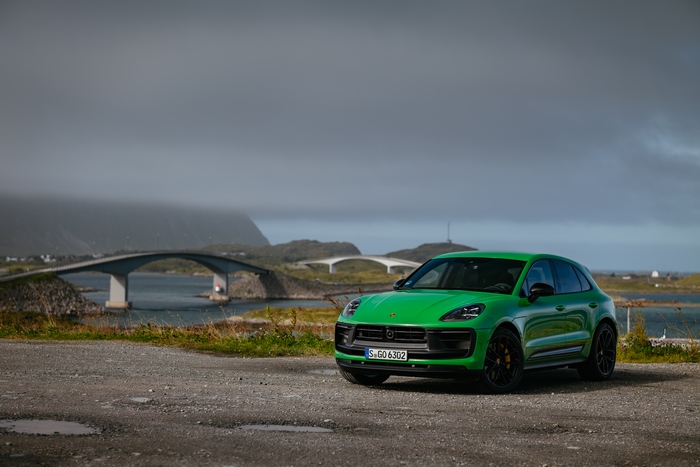 Green Porsche Macan GTS SUV by scenic coastal bridges