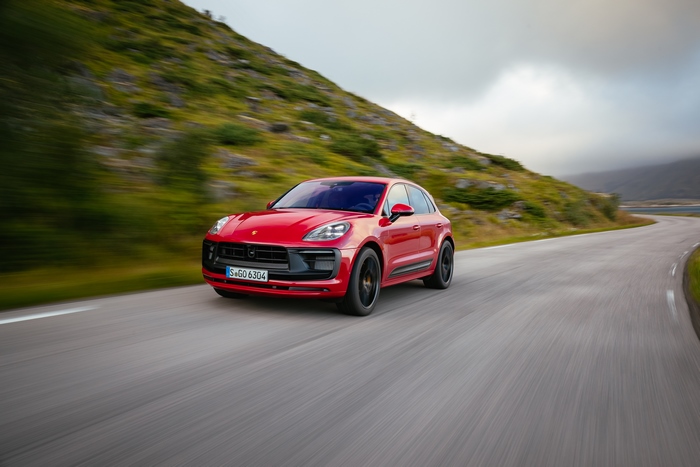 Red Porsche Macan GTS SUV driving on a scenic road