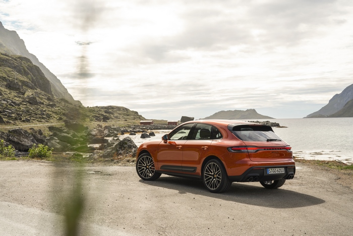 Orange Porsche Macan S SUV on a scenic coastal road