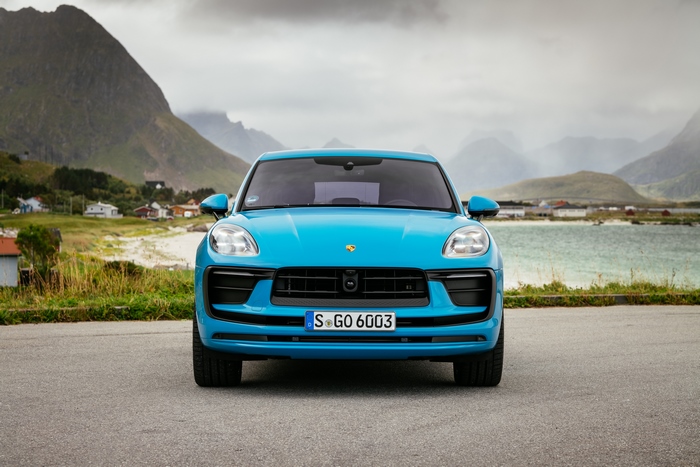Blue Porsche Macan SUV in a scenic landscape