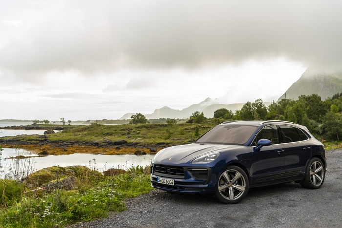Blue Porsche Macan SUV in a scenic coastal landscape