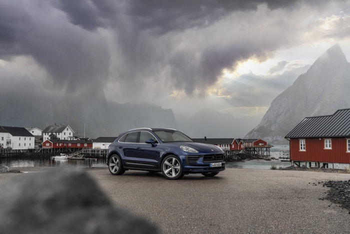 Blue Porsche Macan SUV in a dramatic mountain village