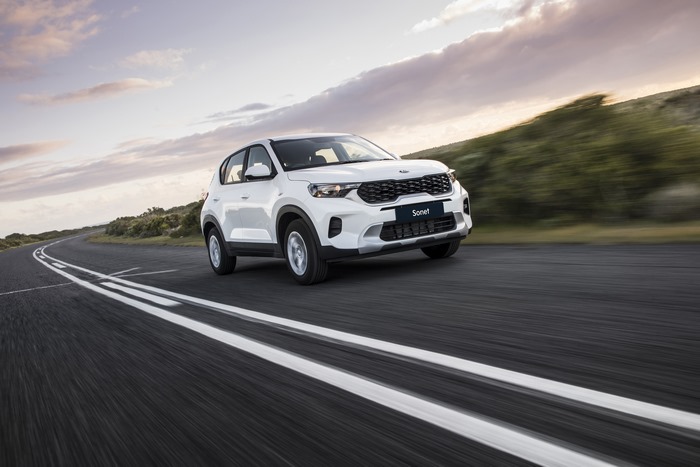 White Kia Sonet LX SUV driving on a road
