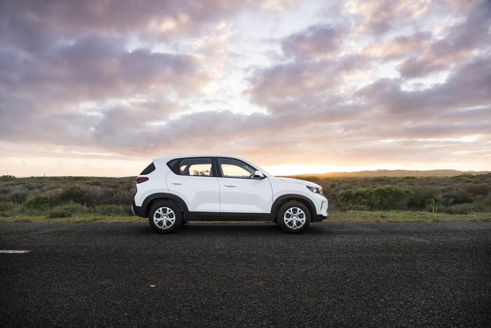 White Kia Sonet LX SUV on road at sunset