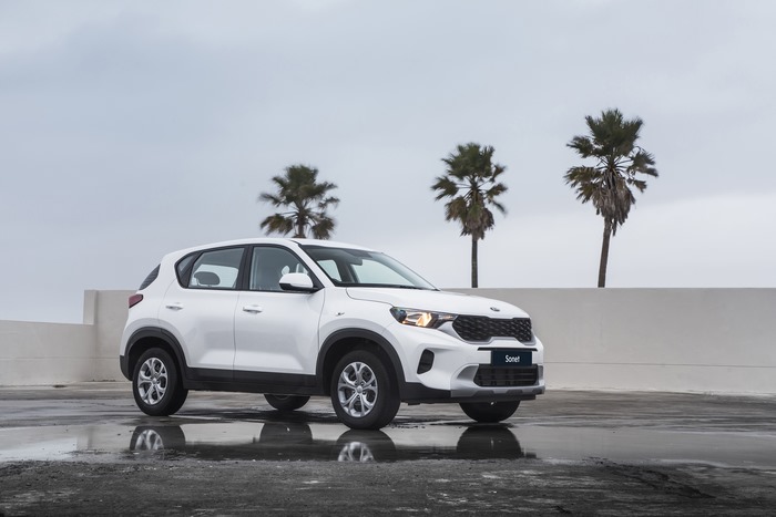 Kia Sonet LX SUV on wet ground with palm trees