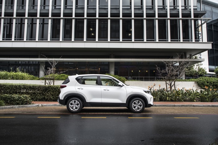 White Kia Sonet LX SUV on a wet city street