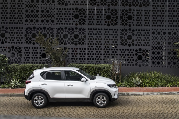 White Kia Sonet LX SUV by modern building