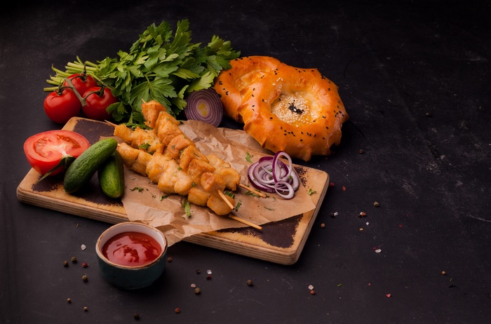 Still Life of Chicken Skewers, Fresh Vegetables, and Tandoor Bread