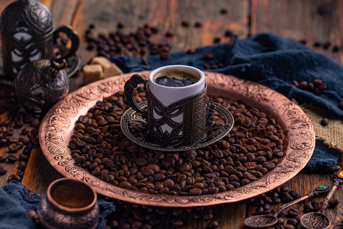 Ornate Coffee Cup and Coffee Beans on Copper Tray