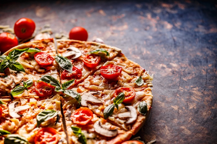 Delicious pizza with fresh tomatoes, mushrooms, and basil