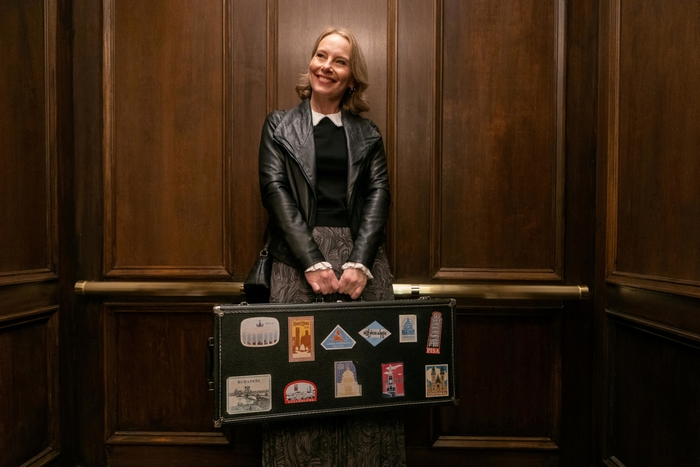 Amy Ryan smiles with travel suitcase in Only Murders In The Building