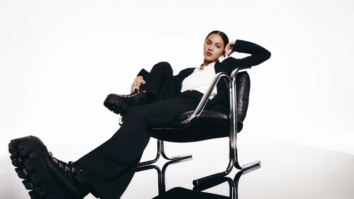 Olivia Rodrigo in Black Outfit Sitting on Chair