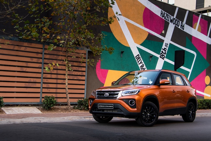 4K Orange Toyota Urban Cruiser SUV by colorful mural