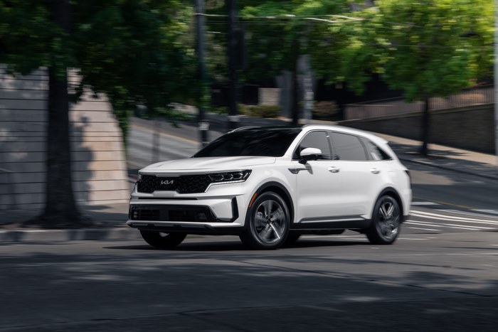 White Kia Sorento PHEV SUV driving on street