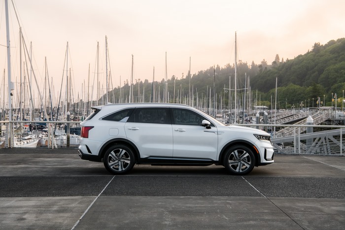 White Kia Sorento PHEV SUV at a marina with sailboats