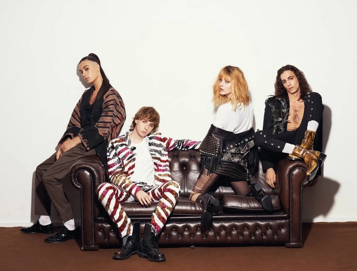 Maneskin band members posing on a couch
