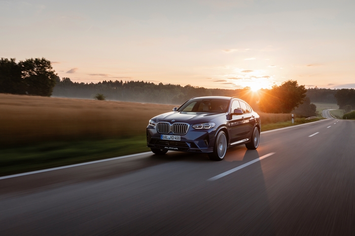 BMW Alpina XD4 SUV driving at sunset