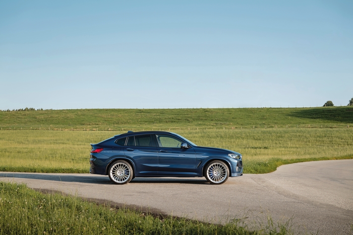 Blue BMW Alpina XD4 SUV on a country road