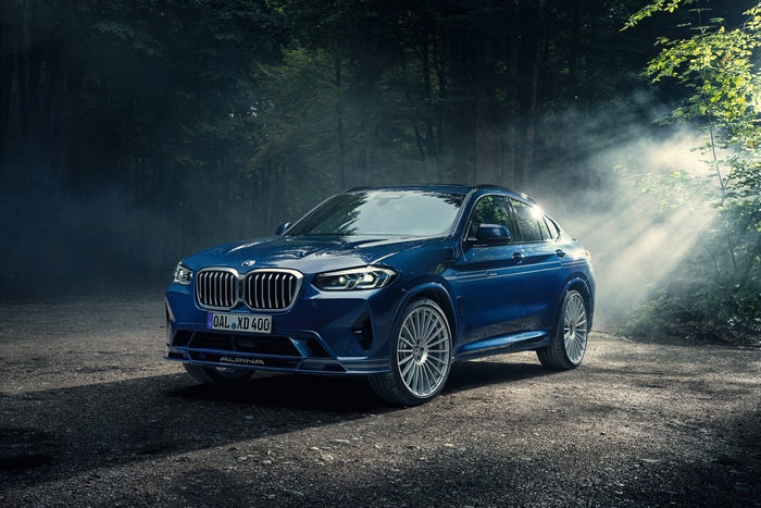 Blue BMW Alpina XD4 SUV in a misty forest