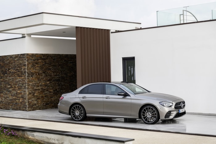 Silver Mercedes-Benz E 450 parked outside a modern home