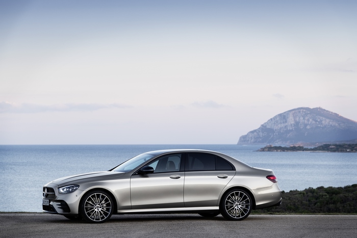 Silver Mercedes-Benz E 450 by the sea and mountain