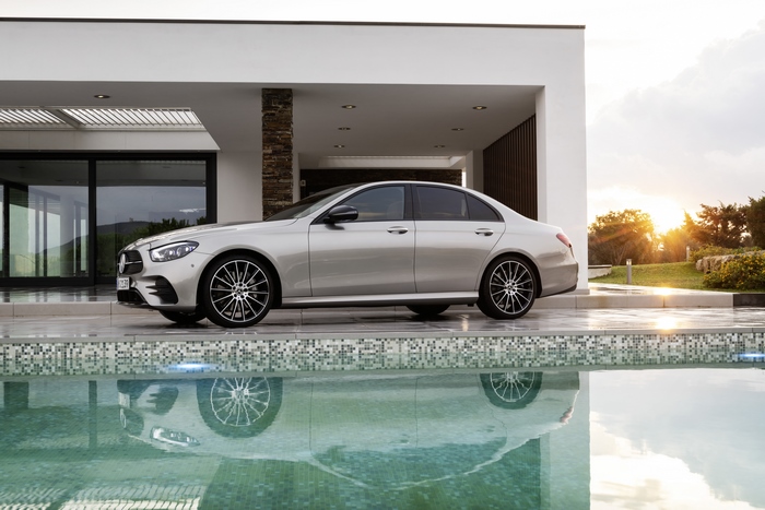 Silver Mercedes-Benz E 450 at modern home with pool