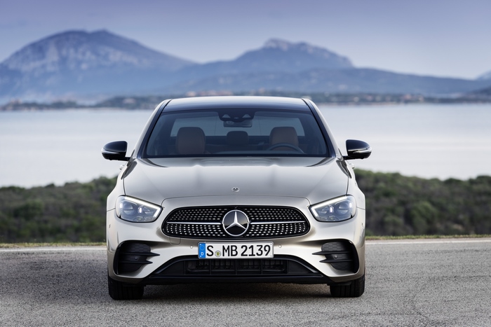 Silver Mercedes-Benz E 450 sedan by the sea and mountains