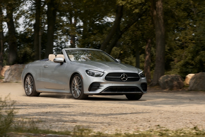 Silver Mercedes-Benz E 450 Cabriolet driving on a dirt road
