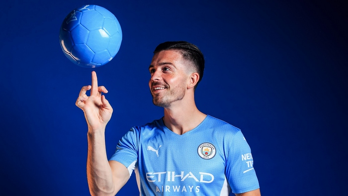 Jack Grealish balancing football in Manchester City kit