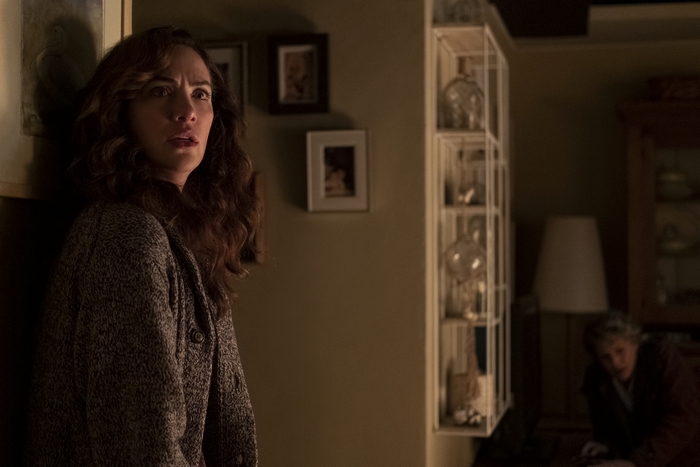 Kate Siegel looking scared in a dimly lit room, Midnight Mass