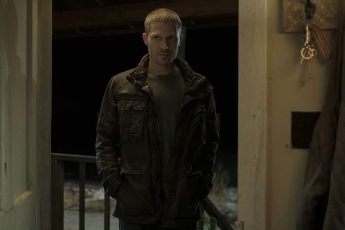 Zach Gilford in Midnight Mass standing in a doorway