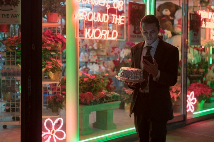 Shiloh Fernandez in The Birthday Cake with cake and phone