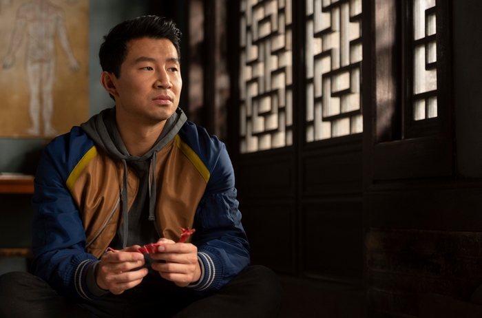 Shang-Chi (Simu Liu) looking thoughtful indoors