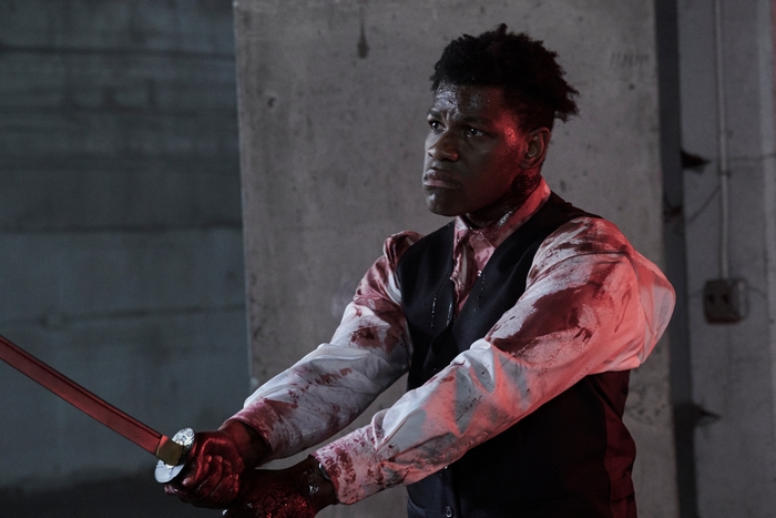 John Boyega holding a blood-covered katana